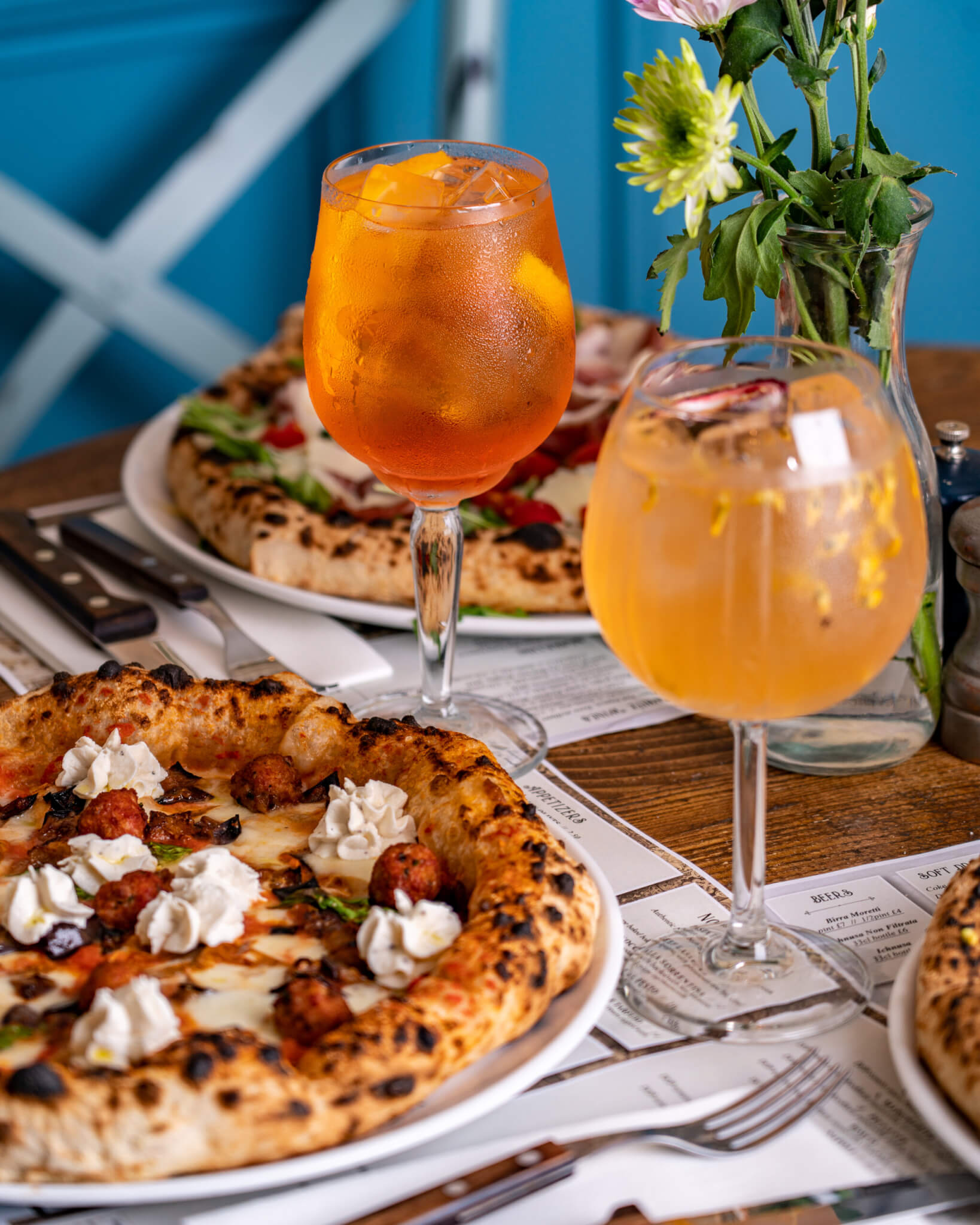 two drinks next to pizzas at cinequecento pizzeria happy hour